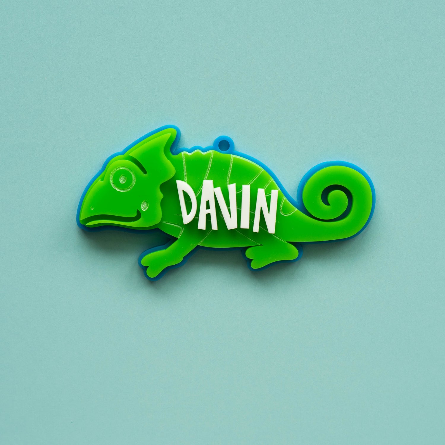 Bright green acrylic chameleon bag tag with custom white name text, laser cut and layered for kids’ backpacks.