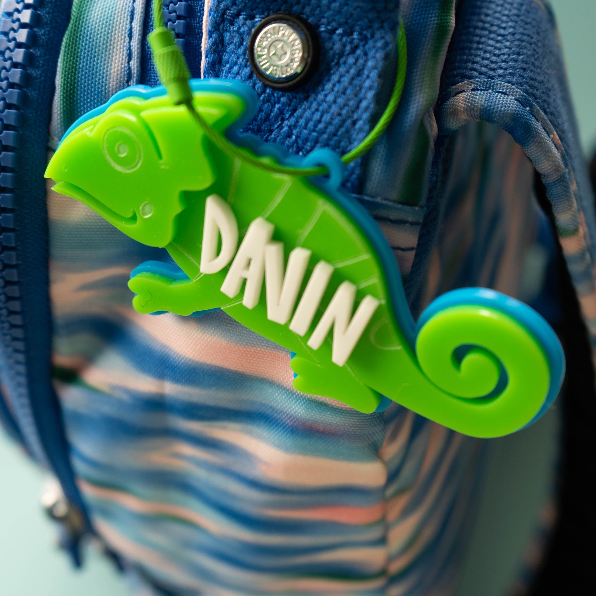 Bright green acrylic chameleon bag tag with custom white name text, laser cut and layered for kids’ backpacks.