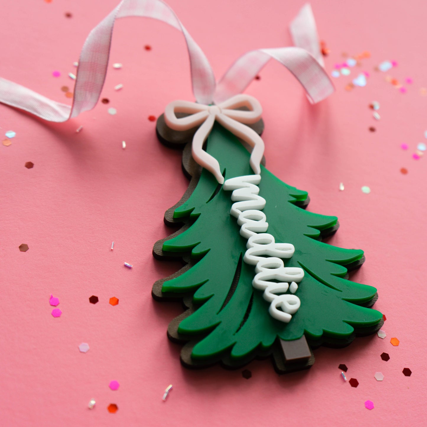 Close-up of layered acrylic Christmas ornament with ribbon.