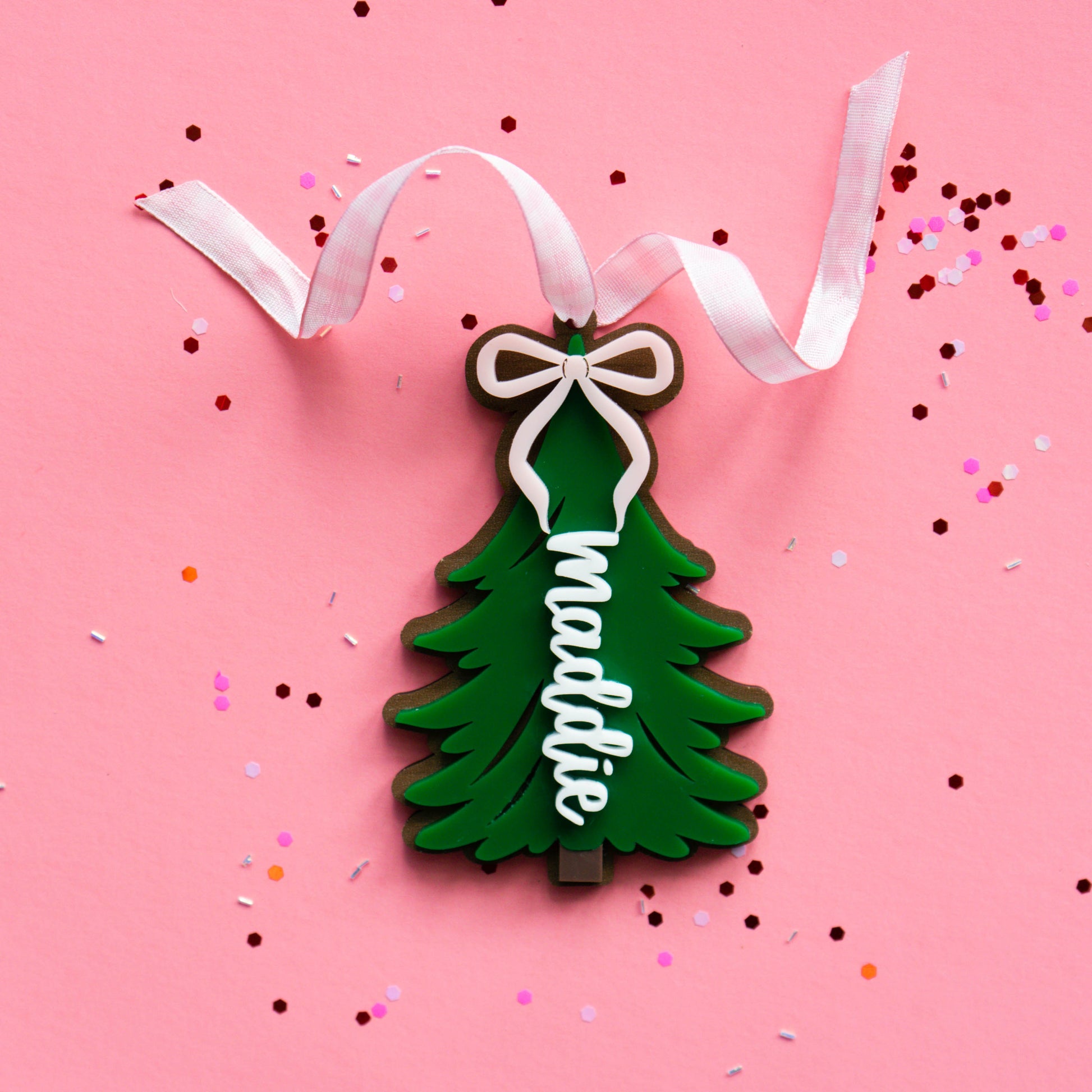 Close-up of layered acrylic Christmas ornament with ribbon.