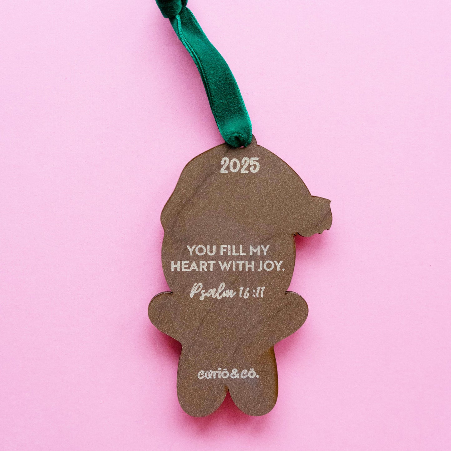 Gingerbread boy Christmas ornament made of layered acrylic with a Santa hat and custom name “Owen,” personalized ornament with Bible verse on the back.