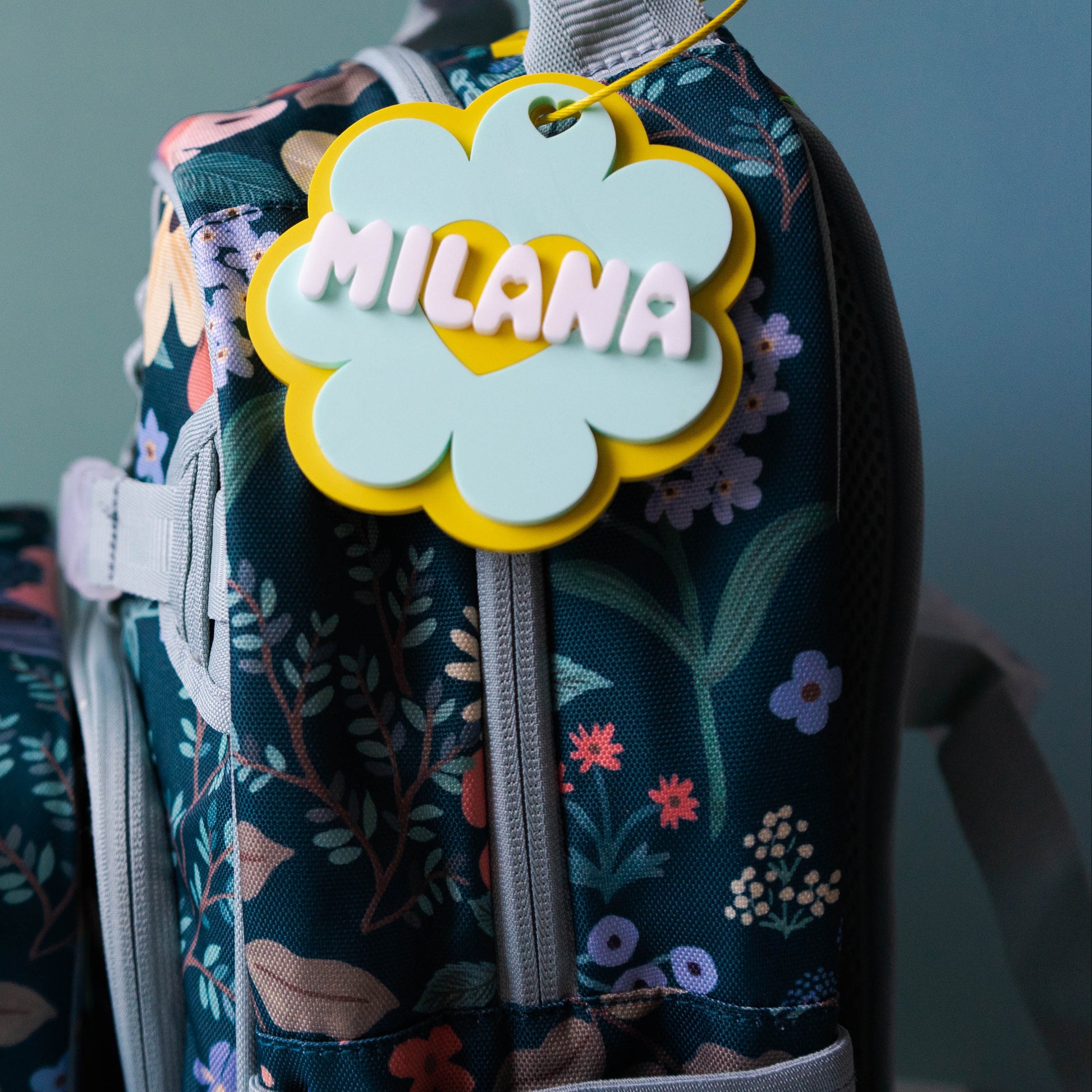 Floral-patterned backpack with 'MILANA' tag on a plain background