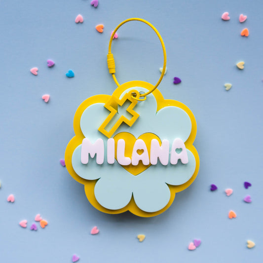 Decorative keychain with 'MILANA' on a blue background with colorful sprinkles