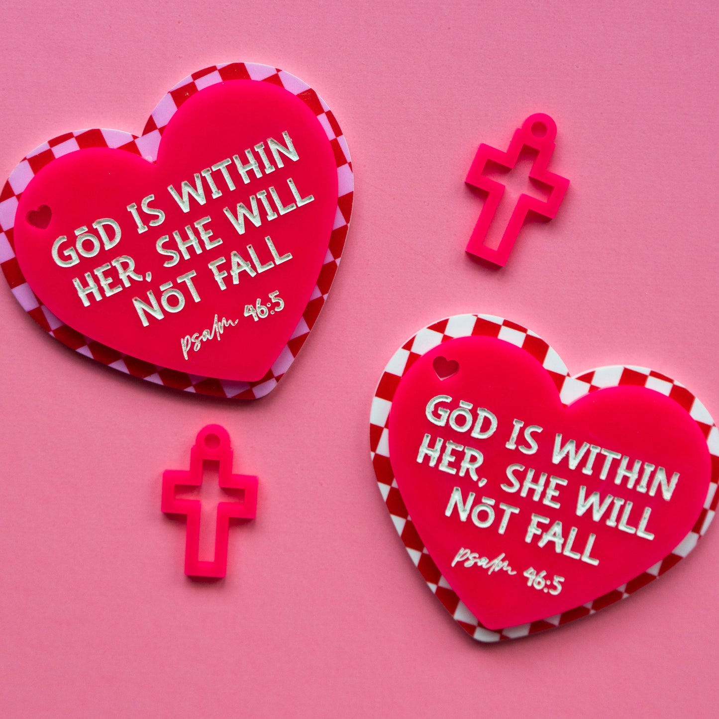 Red heart-shaped bagtags with bible verse text on a pink background
