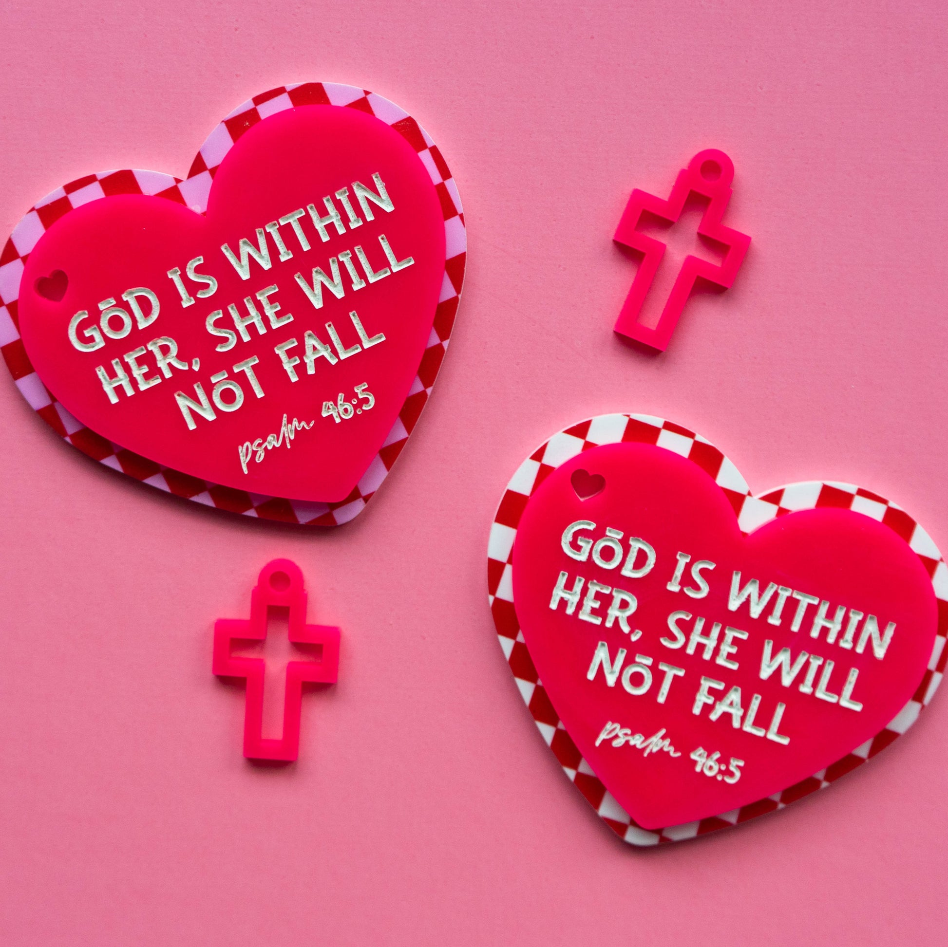 Red heart-shaped bagtags with bible verse text on a pink background