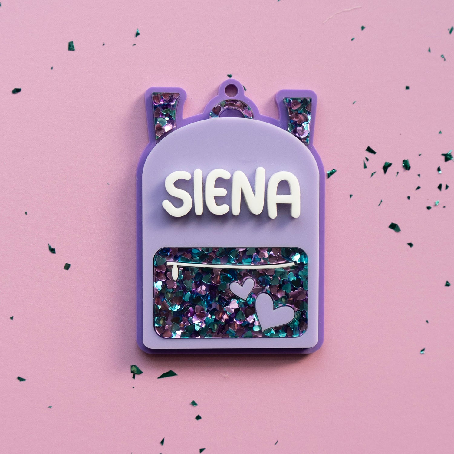 Purple glitter backpack-shaped NFC tag engraved with name and emergency contact — Curio & Co personalized bag tag